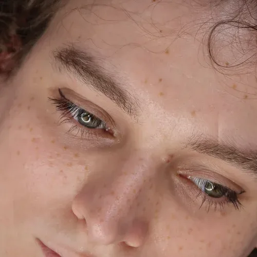 Tilted face with freckles and green eyes